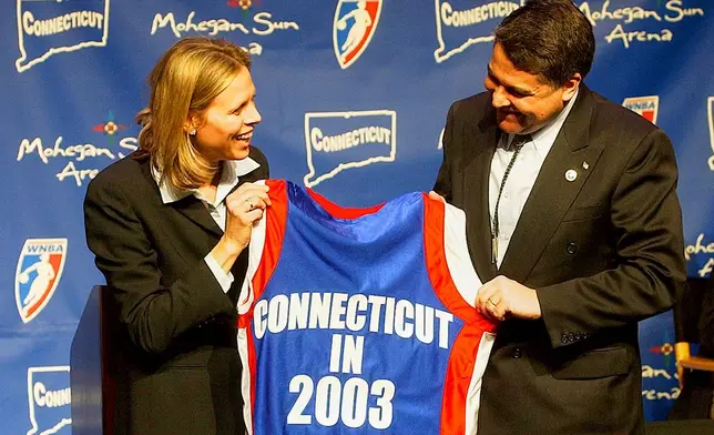 FILE - WNBA League President Val Ackerman, left, and Mohegan Tribe Tribal Chairman Mark Brown hold a basketball shirt of the type that will be worn by the WNBA team Connecticut Sun during a news conference Tuesday, Jan. 28, 2003, at the Mohegan Sun Arena in Uncasville, Conn. (AP Photo/Bob Child, File)