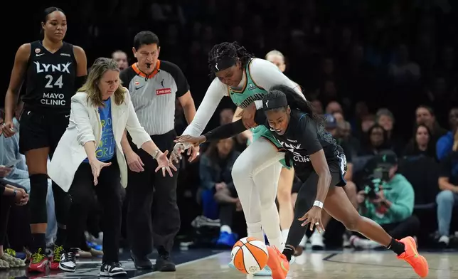 Minnesota Lynx guard Maya Caldwell, right, and New York Liberty center Jonquel Jones, second from right, vie for the ball during the first half of Game 1 in the first round of the WNBA basketball playoffs, Sunday, Sept. 27, 2026, in Minneapolis. (AP Photo/Ellen Schmidt)