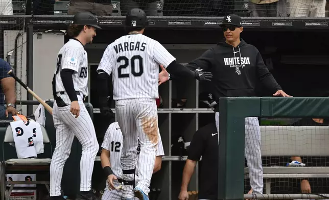 Chicago White Sox's Miguel Vargas (20) celebrates with manager Will Venable, right, at the dugout after hitting a solo home run during the sixth inning of a baseball game against the Detroit Tigers Saturday, Sept. 19, 2026, in Chicago. (AP Photo/Paul Beaty)