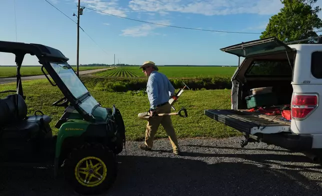 Neal Flanagan, a research scientist at Duke University, carries soil sampling tools Wednesday, May 6, 2026, in Belhaven, N.C. (AP Photo/Joshua A. Bickel)