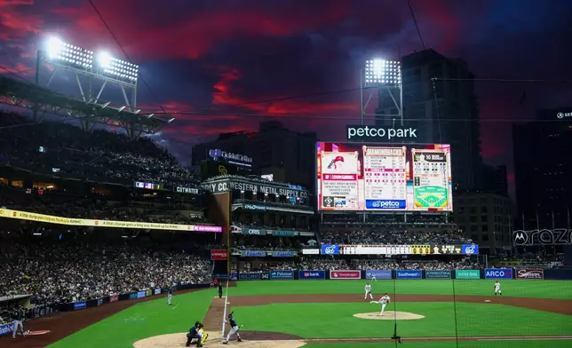 San Diego Padres starting pitcher Walker Buehler, cengter, throws to Arizona Diamondbacks' Corbin Carroll, third from left, in the fourth inning of a baseball game Saturday, Sept. 26, 2026, in San Diego. (AP Photo/Karl Anderson)