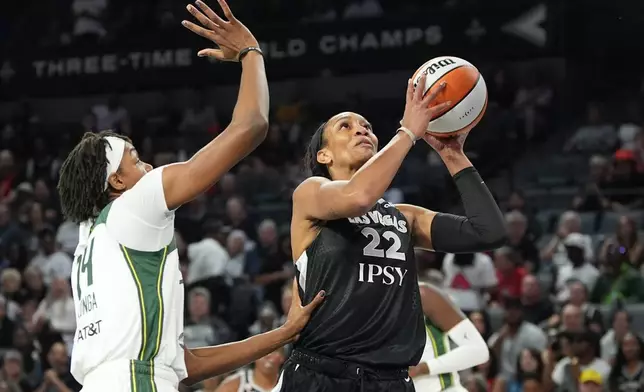 Las Vegas Aces center A'ja Wilson (22) shoots over Seattle Storm center Dominique Malonga (14) during the first half of a WNBA basketball game Sunday, Sept. 20, 2026, in Las Vegas. (AP Photo/John Locher)