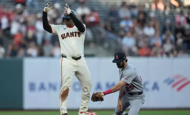 San Francisco Giants' Rafael Devers, left, gestures after hitting a double next to St. Louis Cardinals shortstop Thomas Saggese during the fifth inning of a baseball game, Monday, Sept. 7, 2026, in San Francisco. (AP Photo/Jeff Chiu)