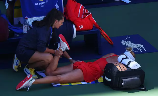 Anastasia Potapova, of Austria, has her leg worked on during a medical timeout during a match against Mirra Andreeva, of Russia, during the fourth round of the U.S. Open tennis championships, Monday, Sept. 7, 2026, in New York. (AP Photo/Andres Kudacki)