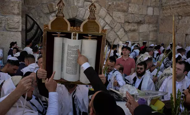 Jewish men participate in a blessing during the holiday of Sukkot, at the Western Wall, the holiest site where Jews can pray, in the Old City of Jerusalem, Monday, Sept. 28, 2026. (AP Photo/Leo Correa)