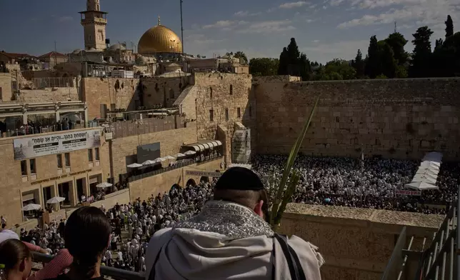 Backdropped by the Dome of the Rock at the Al Aqsa Mosque compound, Jewish men participate in a blessing during the holiday of Sukkot, at the Western Wall, the holiest site where Jews can pray, in the Old City of Jerusalem, Monday, Sept. 28, 2026. (AP Photo/Leo Correa)