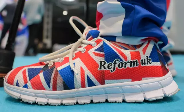 A member wears shoes in Union Flag colours during the Reform party's annual conference at the National Exhibition Centre in Birmingham, England, Friday, Sept. 4, 2026. (AP Photo/Thomas Krych)