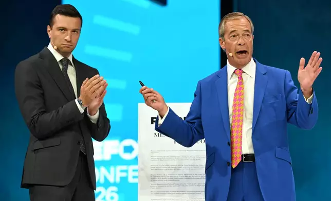 French politician Jordan Bardella, President of National Rally, and Reform Party Leader Nigel Farage, right, stand on the podium during the Reform party's annual conference at the National Exhibition Centre in Birmingham, England, Friday, Sept. 4, 2026. (AP Photo/Thomas Krych)