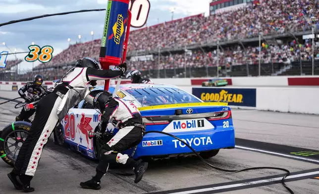 The pit crew for Christopher Bell rushes to complete a pit stop during a NASCAR Cup Series auto race at Darlington Raceway, Sunday, Sept. 6, 2026, in Darlington, S.C. (AP Photo/Matt Kelley)