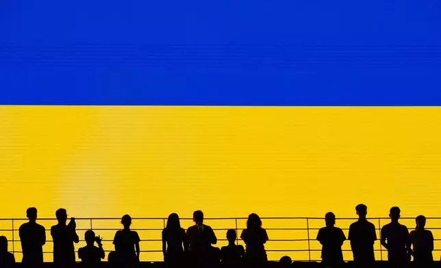 Spectators rise during Ukraine's national anthem at the Billie Jean King Cup women's singles final between Ukraine and the Czech Republic, in Shenzhen, China, Sunday, Sept. 27, 2026. (AP Photo/Andy Wong)