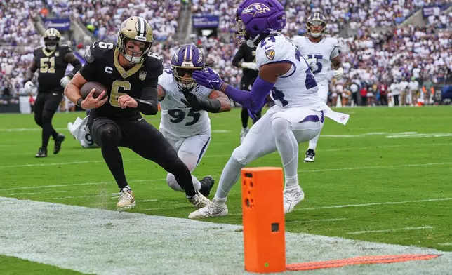 New Orleans Saints quarterback Tyler Shough (6) is forced out of bounds by Baltimore Ravens linebacker Tavius Robinson (95) and safety Malaki Starks (24), short of the first down marker near the goal line, in the first half of an NFL football game in Baltimore, Sunday, Sept. 20, 2026. (AP Photo/Stephanie Scarbrough)