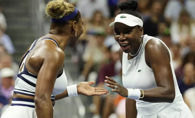 Venus Williams, right, and Serena Williams, of the United States, slap hands during the third set as they play against Hao-Ching Chan, of Taiwan, and Maya Joint, of Australia, during a women's doubles match at the U.S. Open tennis championships, Friday, Sept. 4, 2026, in New York. (AP Photo/Adam Hunger)