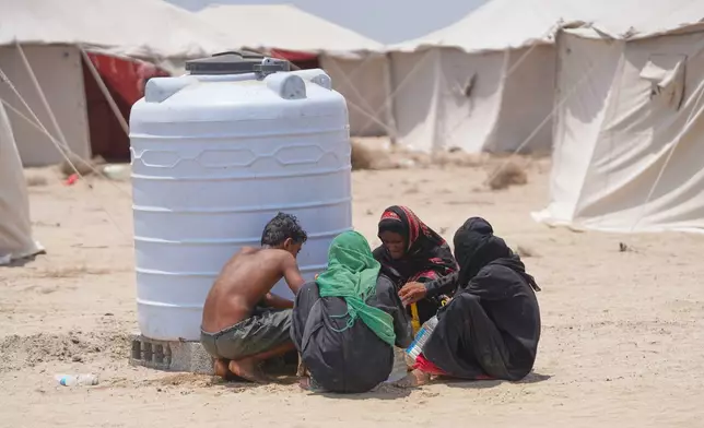 Displaced Yemenis chat at Al-Firdaws camp in Ras Imran, just outside Aden, Yemen, Monday, Sept. 14, 2026. (AP Photo/Abdulnasser Alseddik)