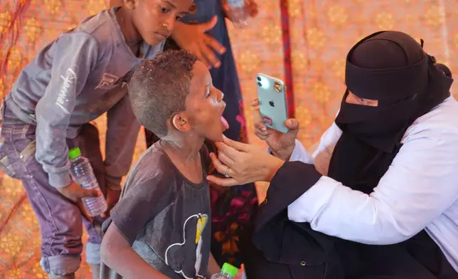 A doctor examines a displaced child at Al-Firdaws camp in Ras Imran, just outside Aden, Yemen, Monday, Sept. 14, 2026. (AP Photo/Abdulnasser Alseddik)