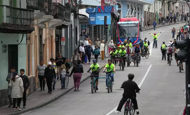 FILE - Volunteers with the "Ciegocleta" initiative guide visually impaired participants on tandem bicycles in Quito, Ecuador, Sunday, Aug. 30, 2026. (AP Photo/Dolores Ochoa)