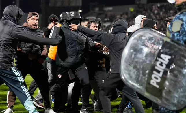 Fans of Argentina's Platense invade the field at the end of a Copa Libertadores quarter final second leg soccer match against Brazil's Fluminense in Buenos Aires, Argentina, Tuesday, Sept. 15, 2026. (AP Photo/Gustavo Garello)