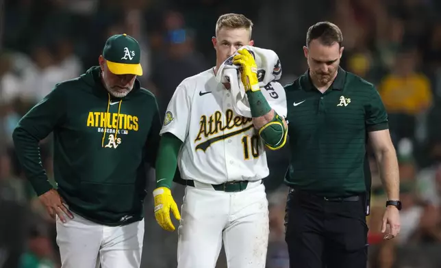 Athletics' Brian Serven, middle, walks off the field after being hit in the eye when he fouled off a bunt during the sixth inning of a baseball game against the Los Angeles Angels Wednesday, Sept. 23, 2026, in West Sacramento, Calif. (AP Photo/Scott Marshall) CORRECTION : Corrects to being hit in the eye when he fouled off a bunt instead of being hit by a pitch.