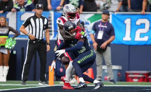 Seattle Seahawks cornerback Josh Jobe, front, causes pass interference against New England Patriots wide receiver A.J. Brown, behind, during the first half of an NFL football game, Wednesday, Sept. 9, 2026, in Seattle. (AP Photo/Lindsey Wasson)