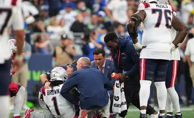 New England Patriots wide receiver A.J. Brown (1) is tended to on the field during the second half of an NFL football game against the Seattle Seahawks, Wednesday, Sept. 9, 2026, in Seattle. (AP Photo/Lindsey Wasson)