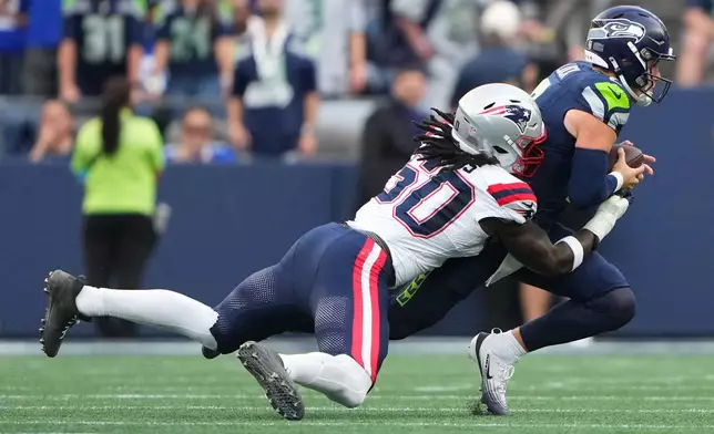 New England Patriots linebacker Gabe Jacas, left, sacks Seattle Seahawks quarterback Drew Lock, right, during the first half of an NFL football game, Wednesday, Sept. 9, 2026, in Seattle. (AP Photo/Lindsey Wasson)