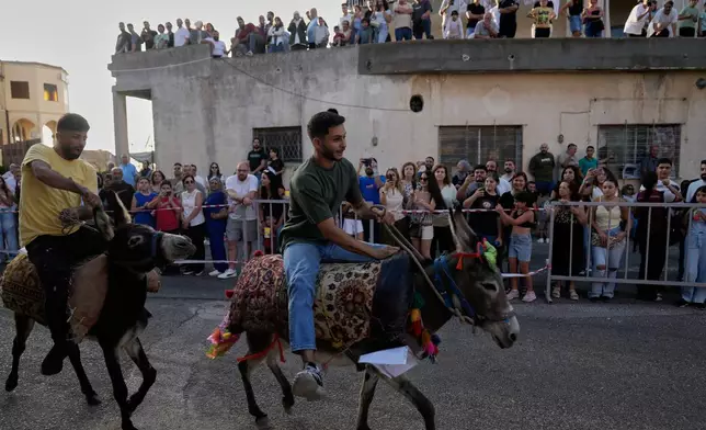 Participants race their donkeys during the traditional summer donkey race in Roum village, southern Lebanon, Sunday, Sept. 6, 2026. (AP Photo/Hussein Malla)