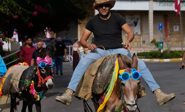 A participant races his donkey during the traditional summer donkey race in Roum village, southern Lebanon, Sunday, Sept. 6, 2026. (AP Photo/Hussein Malla)