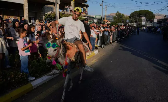 A participant races his donkey during the summer donkey race in Roum village, southern Lebanon, Sunday, Sept. 6, 2026. (AP Photo/Hussein Malla)