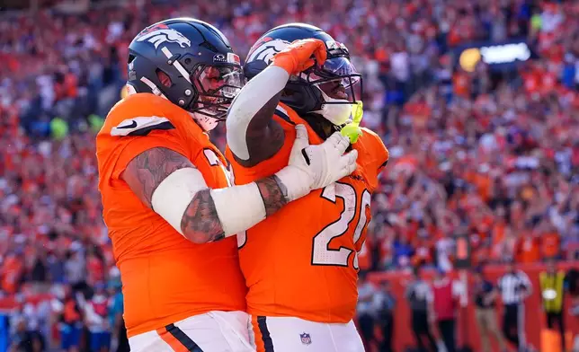 Denver Broncos running back Jonah Coleman (20) is congratulated by Ben Powers after Coleman scored a touchdown against the Jacksonville Jaguars in the second half of an NFL football game in Denver, Sunday, Sept. 20, 2026. (AP Photo/David Zalubowski)