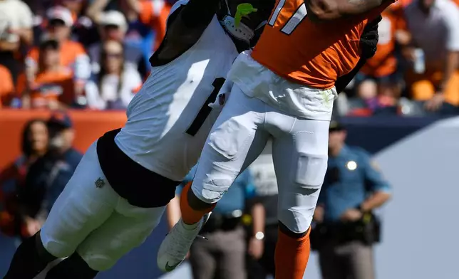 Denver Broncos wide receiver Jaylen Waddle (17) catches a pass for a 49-yard gain as he is defended by Jacksonville Jaguars cornerback Montaric Brown (1) in the first half of an NFL football game in Denver, Sunday, Sept. 20, 2026. (AP Photo/Eric Lutzens)