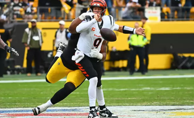 Cincinnati Bengals quarterback Joe Burrow (9) is strip-sacked Pittsburgh Steelers defensive tackle Derrick Harmon (99) by during the second half of an NFL football game in Pittsburgh, Sunday, Sept. 27, 2026. (AP Photo/Justin Berl)