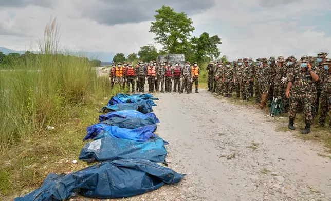 Nepalese army soldiers wait after recovering bodies of flash flood victims from a river in Chitwan, Nepal, Monday, Aug. 31, 2026. (AP Photo/Dar Yasin)