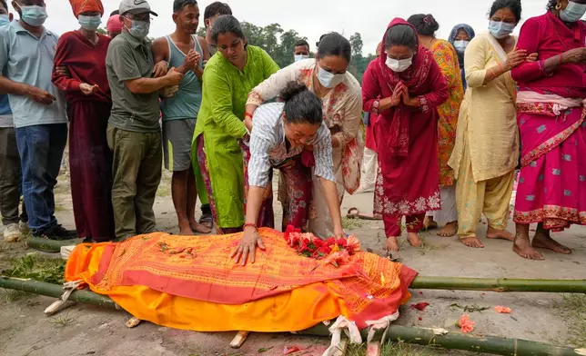 Muna Khadka, center, mother of Aayush Khada, who was killed in flash floods, breaks down during her son's cremation in Chitwan, Nepal, Monday, Aug. 31, 2026. (AP Photo/Dar Yasin)