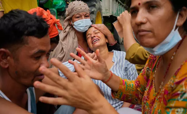 Relatives console Muna Khadka, center, who lost her son Aayush Khada in flash floods, at a cremation ground in Chitwan, Nepal, Monday, Aug. 31, 2026. (AP Photo/Dar Yasin) CORRECTION: Corrects to clarify that this was at a separate cremation ground and not during a mass burial.