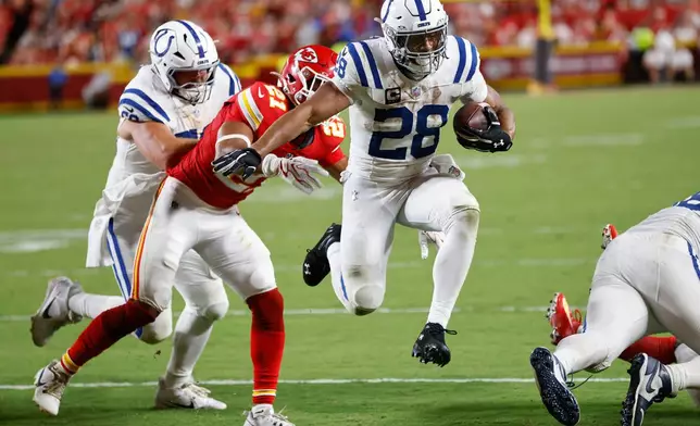 Indianapolis Colts running back Jonathan Taylor (28) scores on a touchdown run past Kansas City Chiefs safety Jaden Hicks (21) during the second half of an NFL football game Sunday, Sept. 20, 2026, in Kansas City, Mo. (AP Photo/Colin E. Braley)