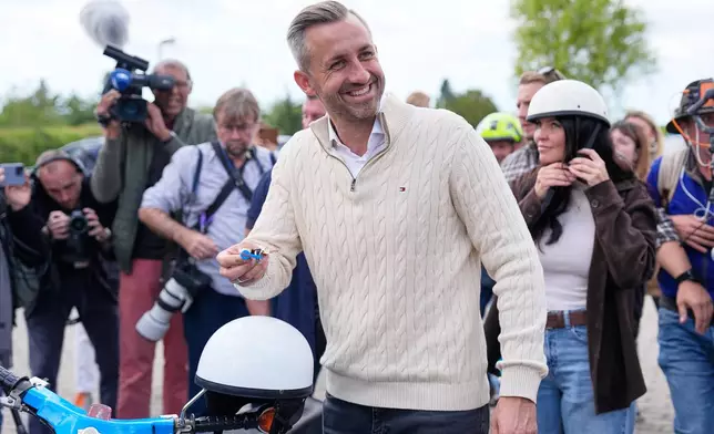 Ulrich Siegmund, top candidate for the "Alternative for Germany" (AfD) party how's his motorcycle keys in party coolers after voting at a polling station during the Saxony-Anhalt state elections in Tangermuende, eastern Germany, Sunday, Sept. 6, 2026. (AP Photo/Matthias Schrader)