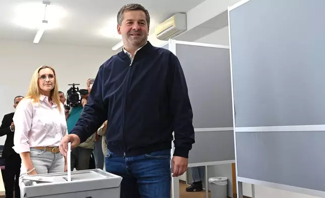 Sven Schulze, Minister-President of Saxony-Anhalt and state chairman of the CDU in Saxony-Anhalt, drops his ballot into the ballot box during the Saxony-Anhalt state election, in Magdeburg, Germany, Sunday Sept. 6, 2026. At left is his wife Kati Schulze. (Klaus-Dietmar Gabbert/dpa via AP)