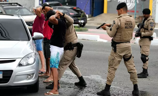 Police search motorists during a security operation in the Lobato neighborhood on the outskirts of Salvador, Bahia state, Brazil, Thursday, Aug. 27, 2026. (AP Photo/Eraldo Peres)