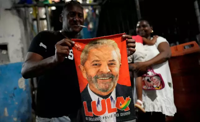 A person displays a banner of Brazilian President Luiz Inacio Lula da Silva, who is running for reelection, during a campaign rally in Salvador, Bahia state, Brazil, Friday, Aug. 28, 2026. (AP Photo/Eraldo Peres)