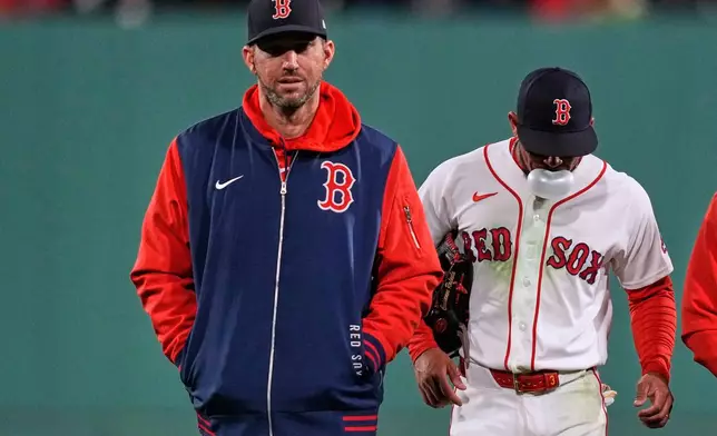 Boston Red Sox's Ceddanne Rafaela, right, blows a bubble while being taken out of the game by manager Chad Tracy after an apparent injury following the second inning of a baseball game against the Cleveland Guardians, Wednesday, Sept. 23, 2026, in Boston. (AP Photo/Charles Krupa)