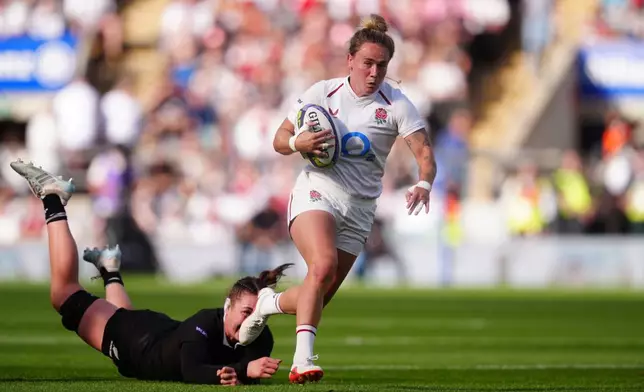 England's Megan Jones gets past the tackle of New Zealand's Maiakawanakaulani Roos during the WXV Global Series match between England and New Zealand in London, Saturday Sept. 26, 2026. (David Davies/PA via AP)