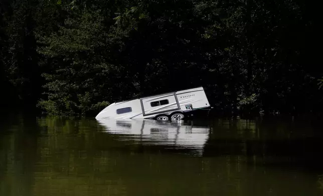 FILE - A camper is partly submerged under water Aug. 3, 2022, in Carr Creek Lake, near Hazard, Ky. (AP Photo/Brynn Anderson, File)