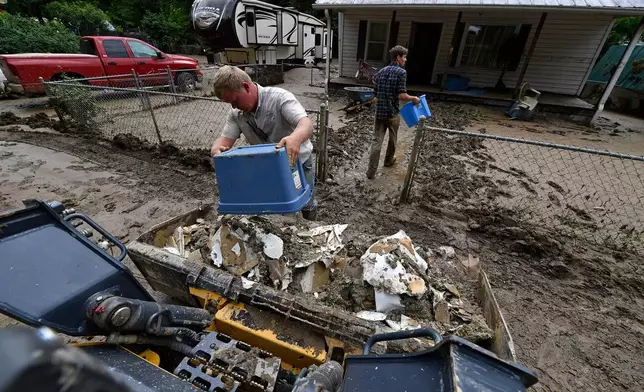 FILE - Volunteers from the local mennonite community clean a flood-damaged property from a house at Ogden Hollar in Hindman, Ky., July 30, 2022. (AP Photo/Timothy D. Easley, File)