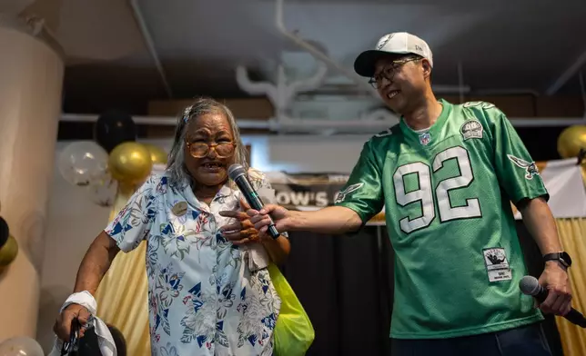 Host and volunteer Soohyung Lee, right, holds a microphone for contestant Roxanne Tomiyasu during Skid Row's inaugural talent show in downtown Los Angeles, Saturday, Sept. 19, 2026. (AP Photo/Jae C. Hong)