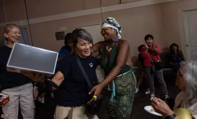Deoujahne Darc, center right, is congratulated by Bok Seo, a volunteer from a local Korean church, after winning first prize at Skid Row’s inaugural talent show in downtown Los Angeles, Saturday, Sept. 19, 2026. (AP Photo/Jae C. Hong)