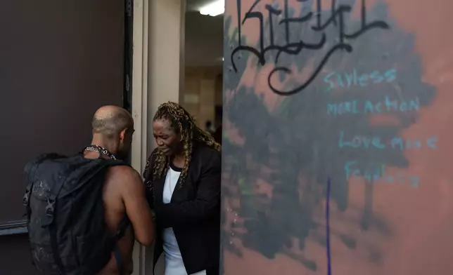 Evangelist Geraldine Hughes, right, a judge at Skid Row’s inaugural talent show, prays with a homeless person outside Lifeway Church in downtown Los Angeles, Saturday, Sept. 19, 2026. (AP Photo/Jae C. Hong)