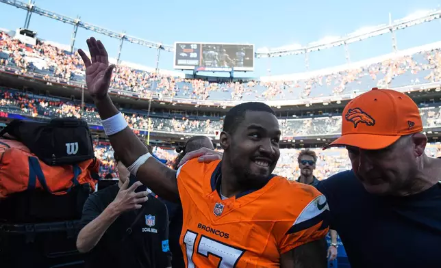 Denver Broncos wide receiver Jaylen Waddle, center, waves to fans as he leaves the field after an NFL football game against the Jacksonville Jaguars, Sunday, Sept. 20, 2026, in Denver. (AP Photo/Eric Lutzens)