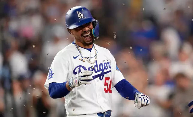 Los Angeles Dodgers' Mookie Betts has seeds thrown at him after hitting a two-run home run during the third inning of a baseball game against the Cincinnati Reds, Wednesday, Sept. 9, 2026, in Los Angeles. (AP Photo/Mark J. Terrill)