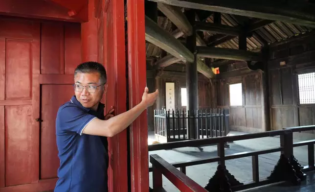 Shu Chenghai, director of social education at Wudang Museum points towards where twelve beams are mortised and interlocked at varying angles the Wuyun Tower in Wudang Mountains in central China's Hubei Province on Sept. 3, 2026. (AP Photo/Achmad Ibrahim)