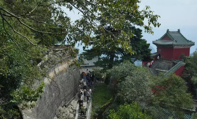Visitors walk near a temple in Wudang Mountains in central China's Hubei Province on Sept. 3, 2026. (AP Photo/Achmad Ibrahim)