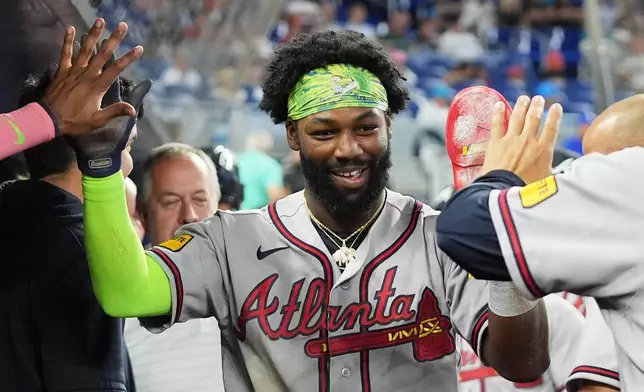 Atlanta Braves' Michael Harris II is congratulated after scoring on a sacrifice fly hit by Matt Olson during the first inning of a baseball game against the Miami Marlins, Saturday, Sept. 26, 2026, in Miami. (AP Photo/Lynne Sladky)